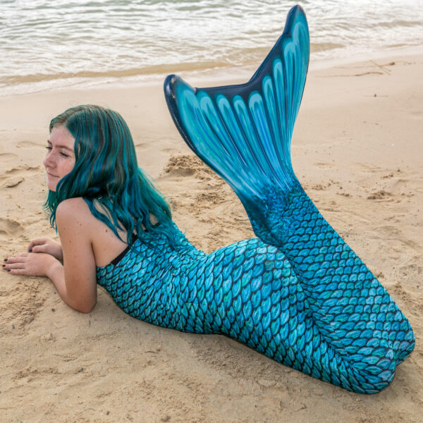 Fin Fun blauwe zeemeerminstaart op het strand - Achteraanzicht met meisje