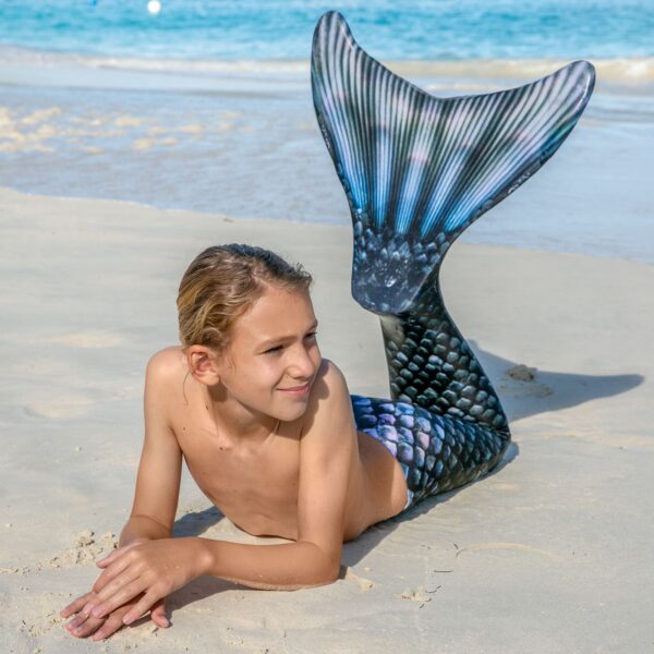 Jongen met zwarte zeemeerminstaart van Fin Fun op het strand